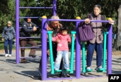 资料照：北京天坛公园里的老年人和他们的独生子女的孙辈在锻炼身体。（2011年10月25日）